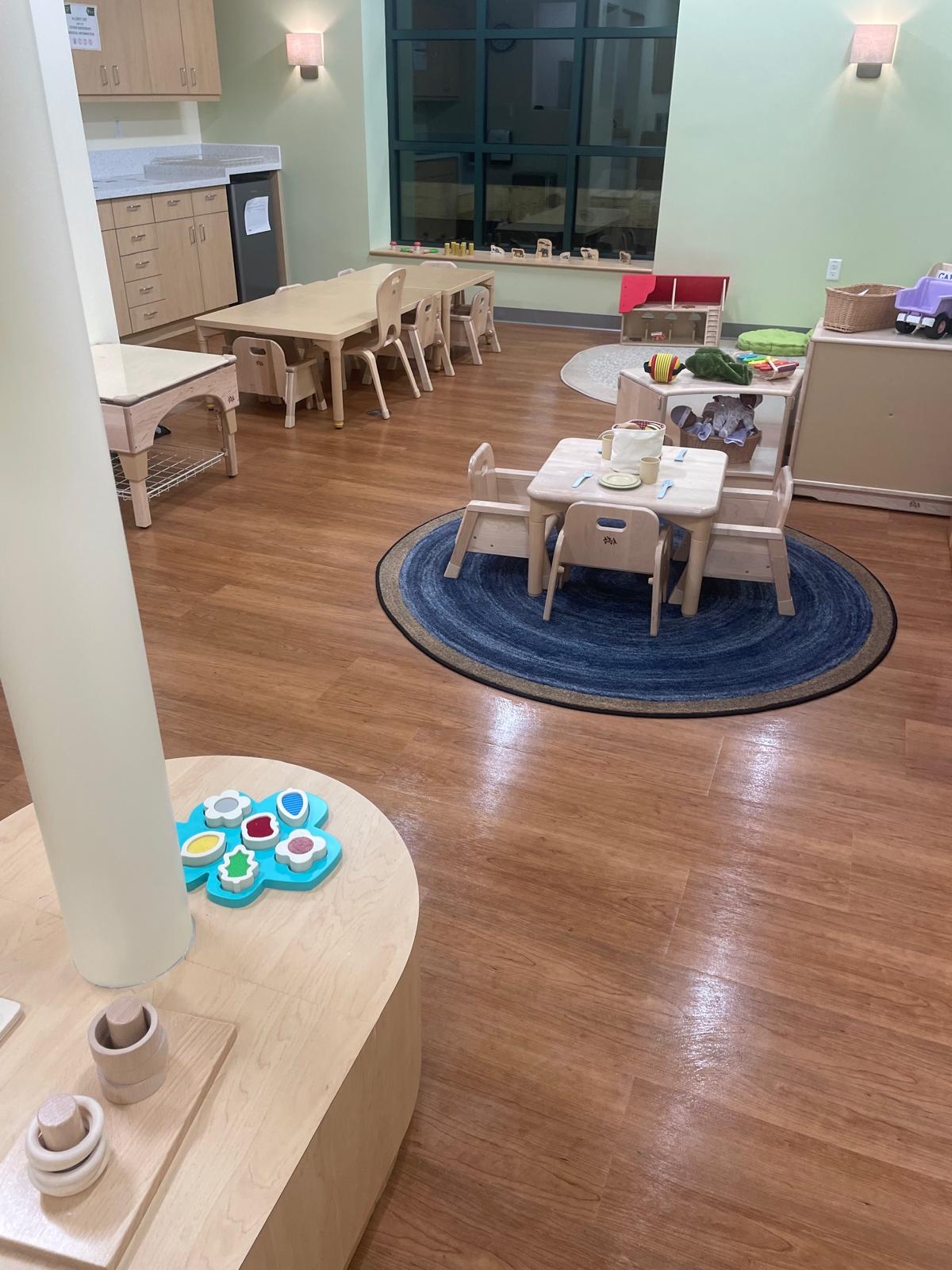 Daycare classroom with sanitized wooden floors, child-sized tables, and a spotless play area maintained by professional cleaning services.