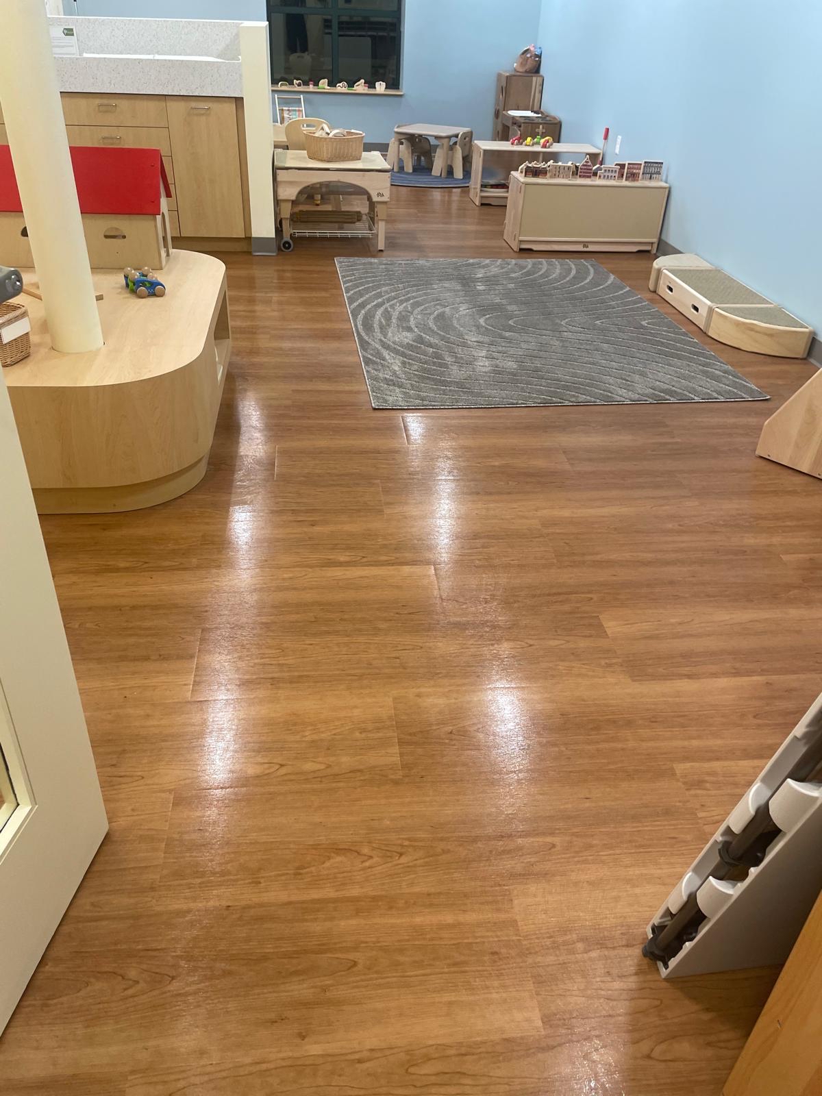 Daycare classroom with polished hardwood floors, child-friendly furniture, and a sanitized environment maintained by professional cleaning services.
