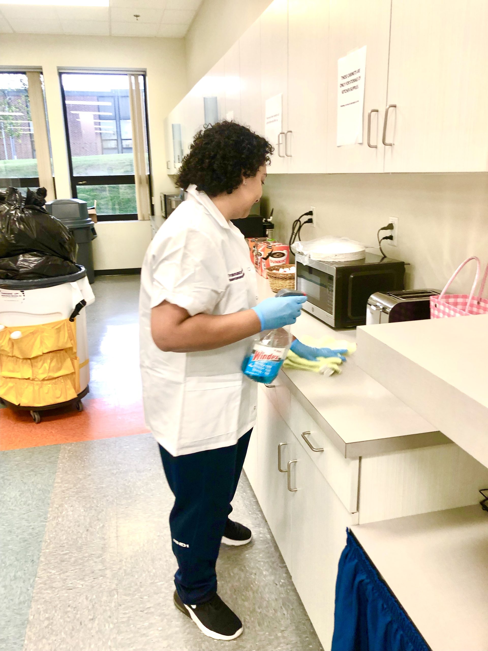 Day porter cleaning office kitchenette and maintaining workplace hygiene, part of Transcend Maintenance commercial cleaning services.