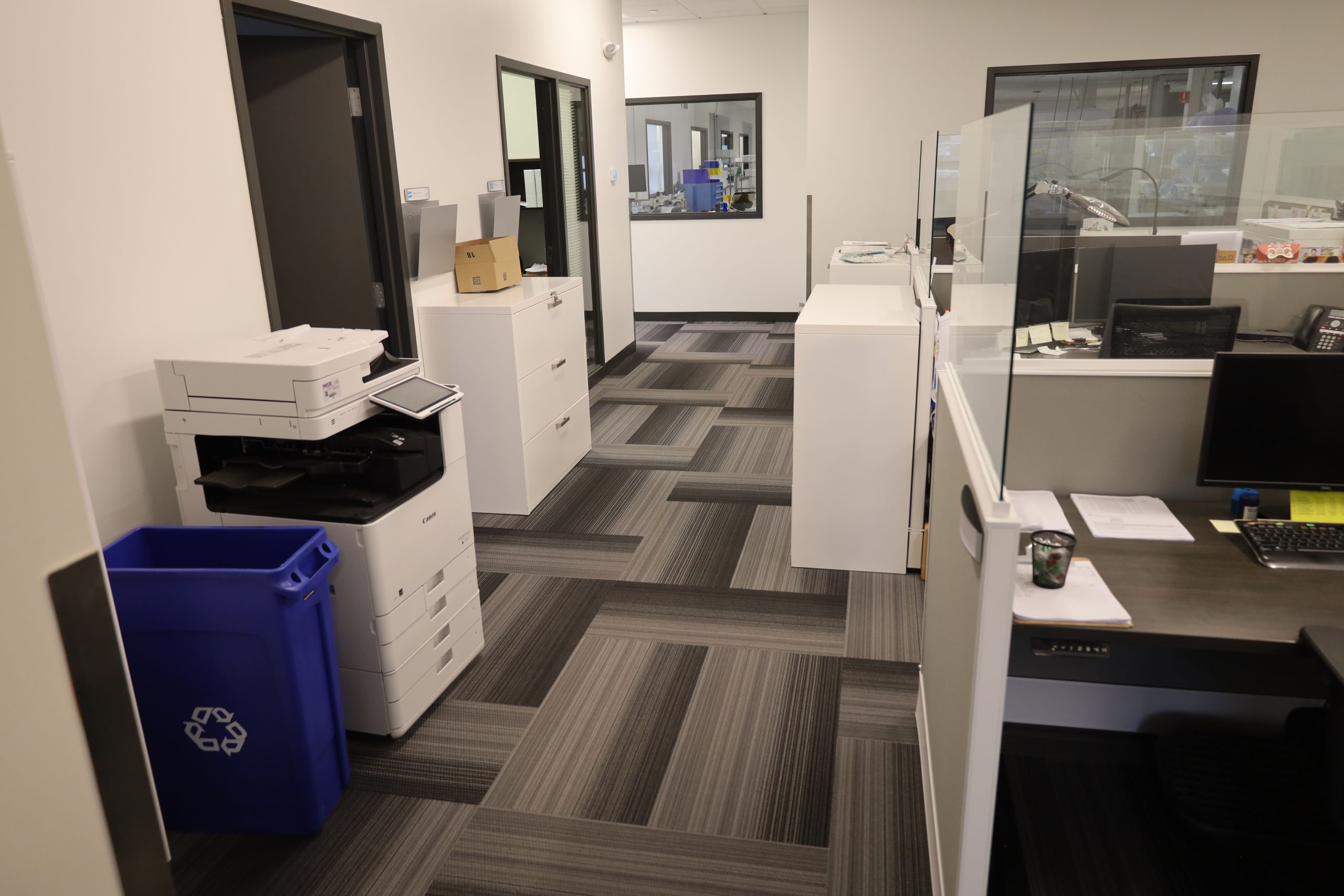 Clean and organized office space with modern carpet flooring and cubicles, maintained by professional commercial cleaning services.