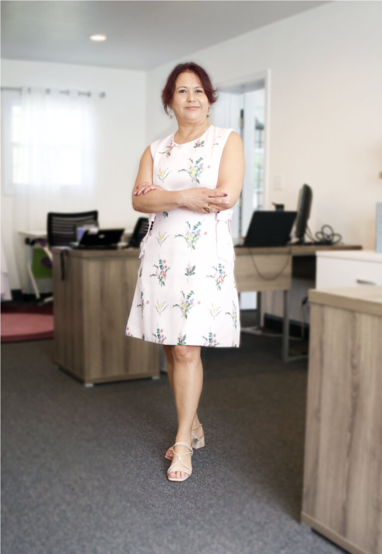 A professional woman standing confidently in a modern office at Transcend Maintenance Services, representing leadership and dedication