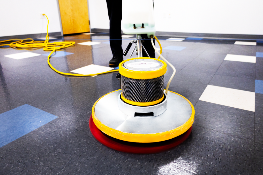 Commercial floor care technician using professional machine for strip and wax services, part of Transcend Maintenance floor cleaning solutions.