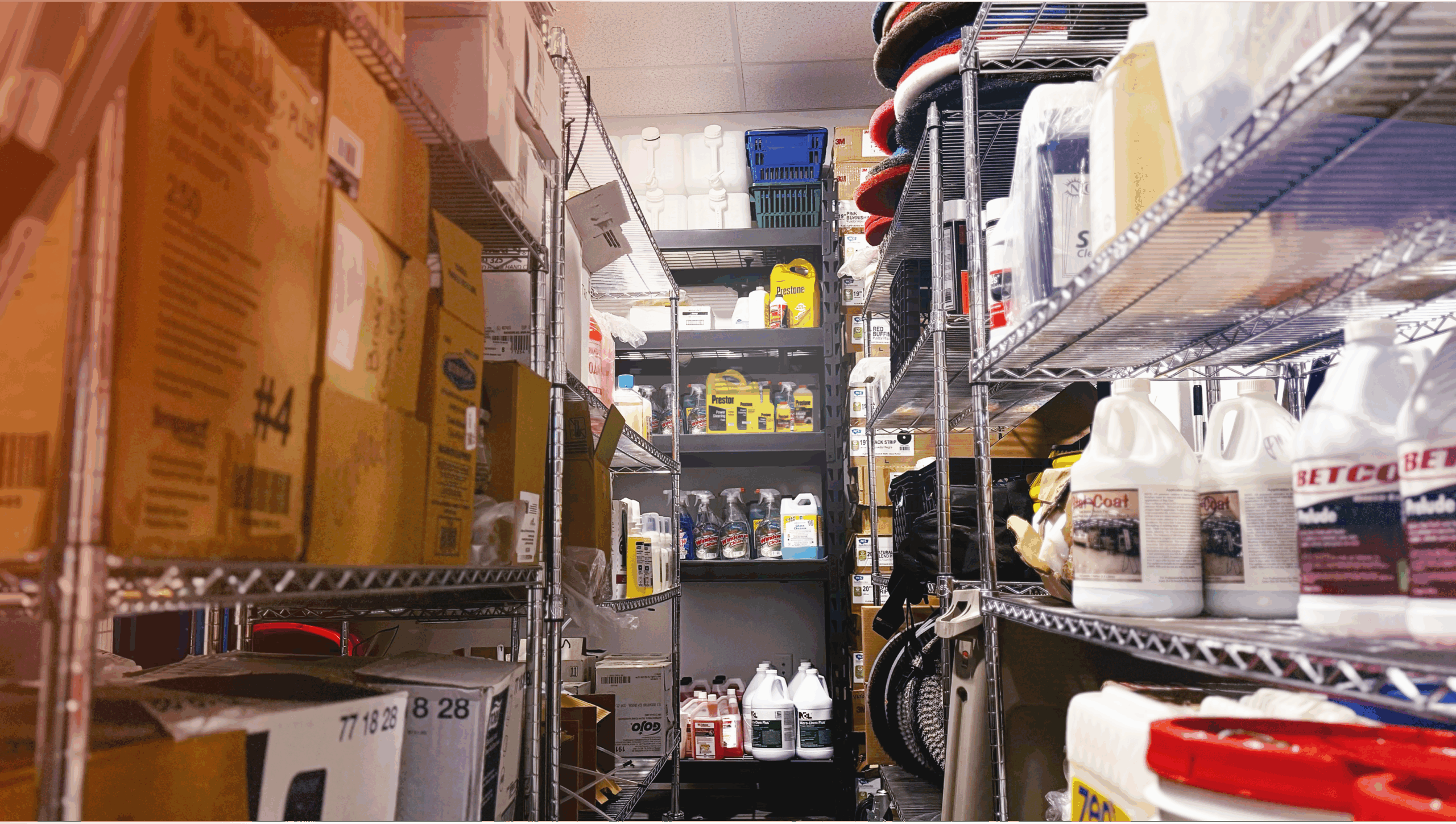 Organized janitorial supply closet with cleaning products, equipment, and storage shelves, highlighting professional commercial cleaning services.
